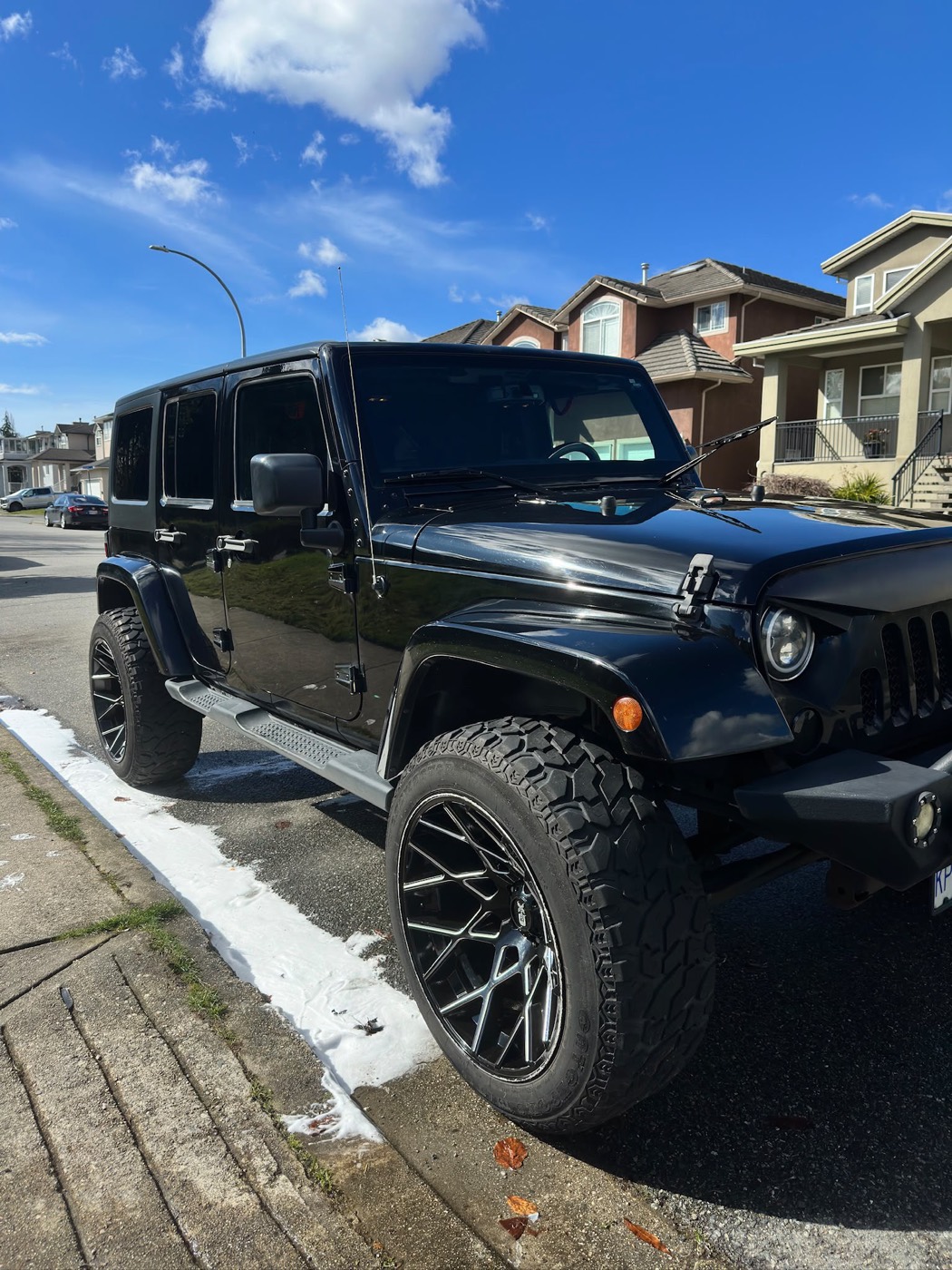 Black Jeep Wrangler Unlimited washed and gleaming in the sun